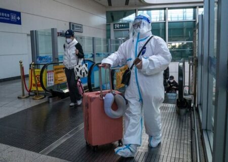 یک مسافر چین با لباس محافظ در برابر کرونا