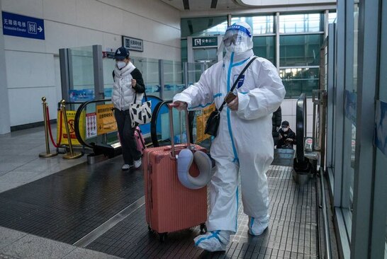یک مسافر چین با لباس محافظ در برابر کرونا