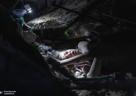 دختری که زیر آوار پس از بمباران توسط هواپیمای اسراییلی گیر گرده است